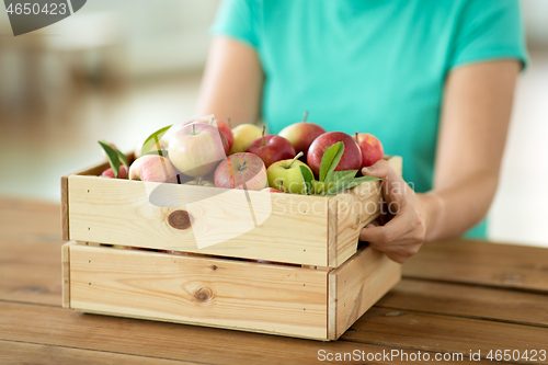 Image of woman with wooden box of ripe apples