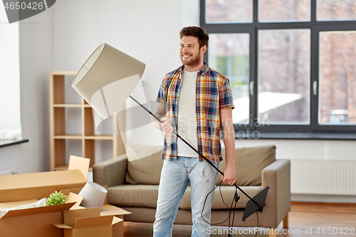 Image of happy man with floor lamp moving to new home