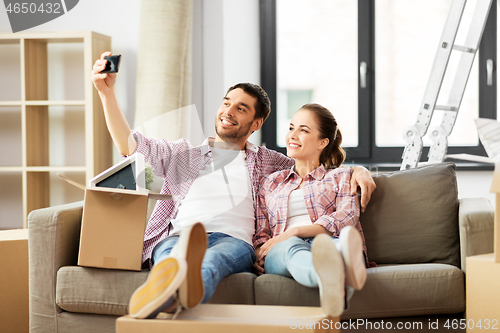 Image of couple taking selfie by smartphone at new home