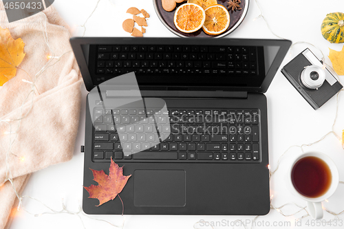 Image of laptop, tea, camera, autumn leaves and sweater