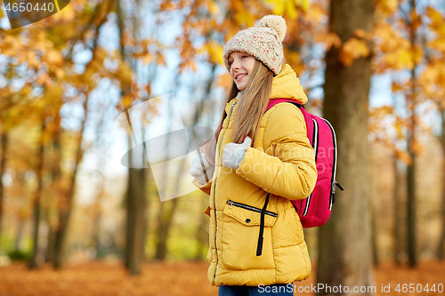 Image of happy student girl with schoolbag at autumn park