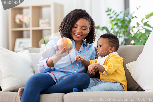 Image of mother and baby playing with ball at home