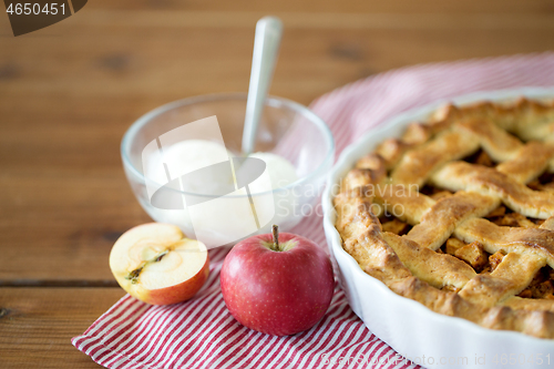 Image of apple pie with ice cream on wooden table