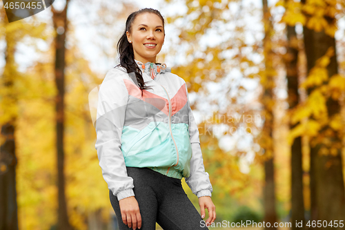 Image of young woman in sports clothing at autumn park