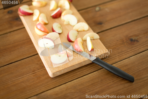 Image of sliced apples and knife on wooden cutting board