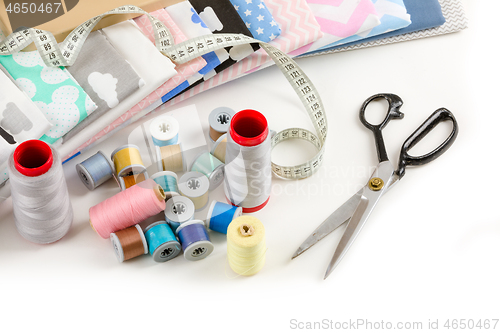 Image of cotton fabric, tailor measurement tape and spools of cotton thre