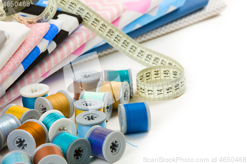 Image of cotton fabric material, tailor measurement tape and spools of co