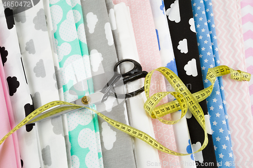 Image of cotton fabric material, tailor measurement tape and scissors