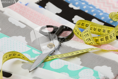 Image of cotton fabric material, tailor measurement tape and scissors