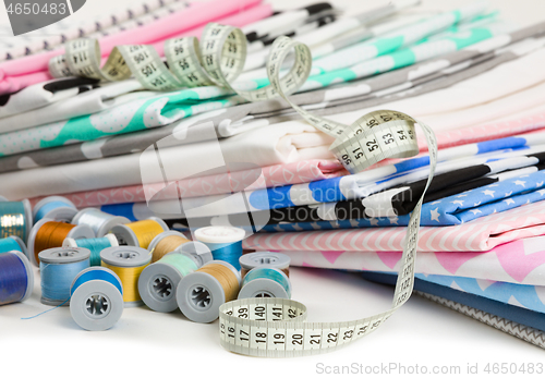 Image of cotton fabric material, tailor measurement tape and spools of co