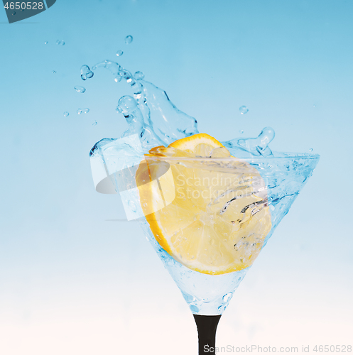 Image of fresh lemon in glass with water splash