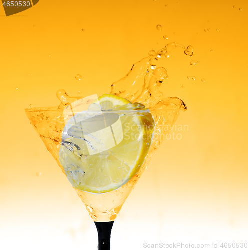 Image of fresh lemon in glass with water splash