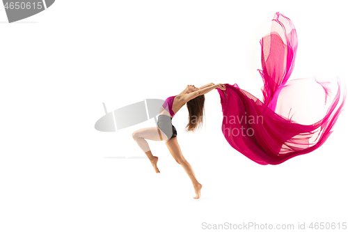 Image of Ballerina. Young graceful female ballet dancer dancing over white studio. Beauty of classic ballet.