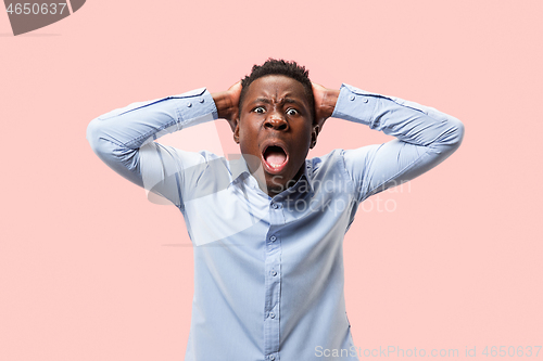 Image of The young emotional angry man screaming on pink studio background