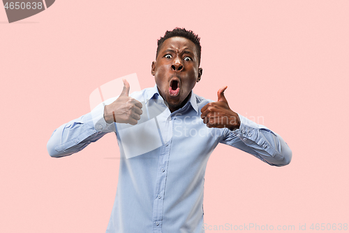 Image of The happy businessman standing and smiling against pink background.