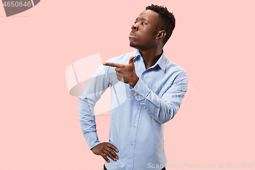 Image of The young attractive man looking suprised isolated on pink