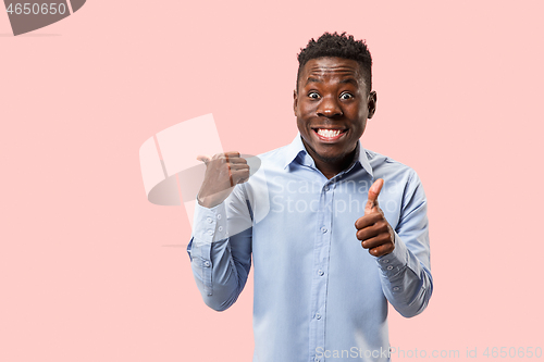 Image of The happy businessman standing and smiling against pink background.