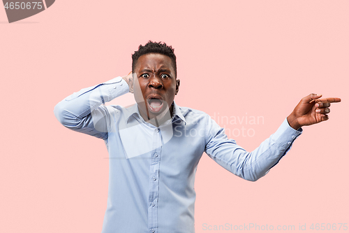 Image of The young attractive man looking suprised isolated on pink