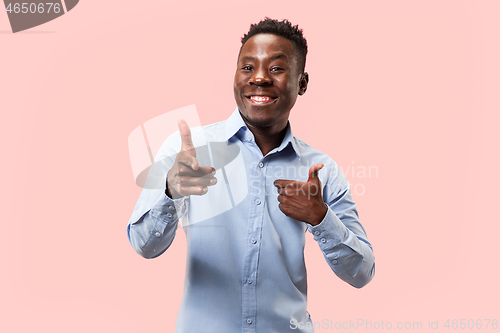 Image of The happy businessman standing and smiling against pink background.