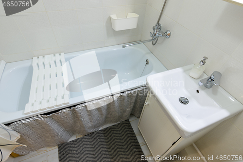 Image of Small bathroom interior with bathtub and washbasin