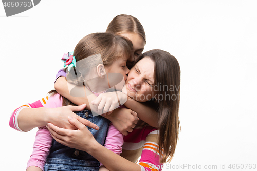 Image of Two daughters kiss mom, isolated on white background