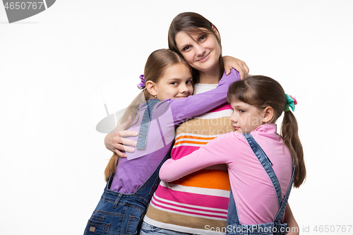 Image of Children hug mom, mom looks happily in frame, isolated on white background