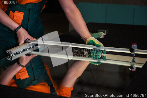 Image of Worker cutting the surface of glass mirror