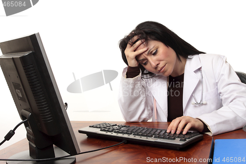 Image of Overworked tired doctor at computer