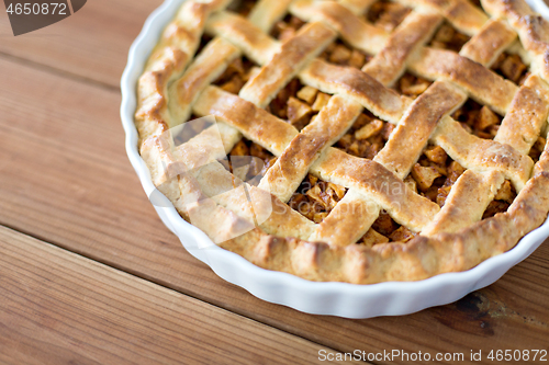 Image of close up of apple pie in mold on wooden table