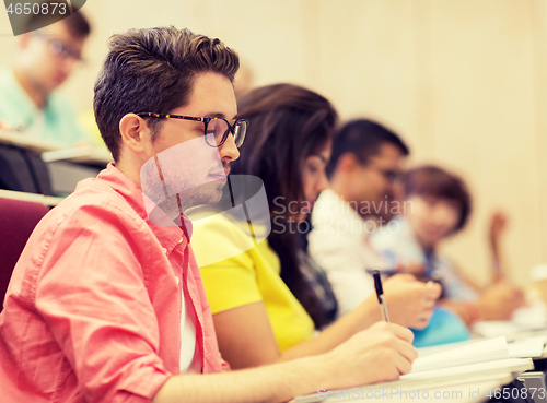 Image of group of students with notebooks in lecture hall