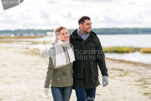 Image of couple walking along autumn beach