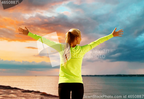 Image of happy woman in sports clothes at seaside