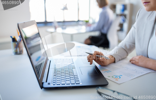 Image of businesswoman with laptop working at office