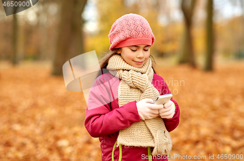 Image of girl with smartphone at autumn park