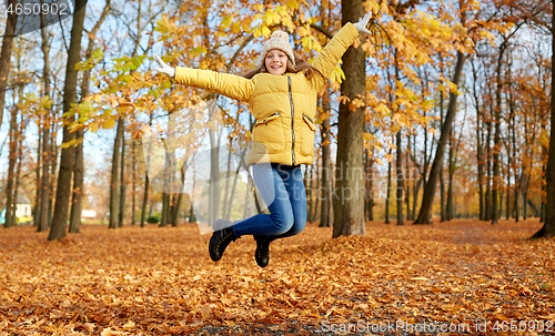 Image of happy girl jumping at autumn park