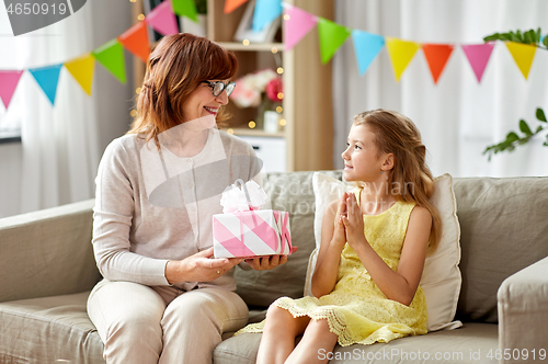 Image of grandmother giving granddaughter birthday gift