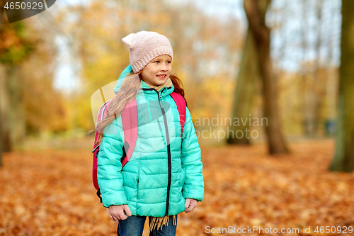 Image of happy student girl with schoolbag at autumn park