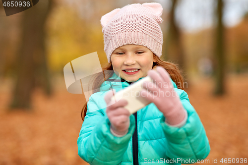 Image of girl with smartphone at autumn park