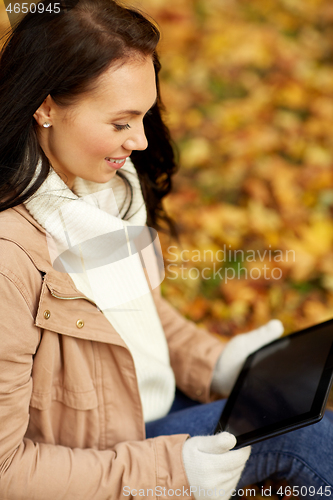 Image of woman with tablet computer at autumn park