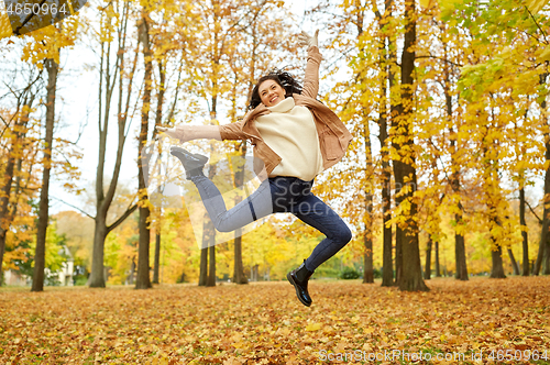 Image of beautiful happy young woman in autumn park