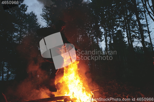 Image of Soldier in Action at Night jumping over fire