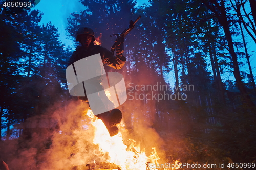 Image of Soldier in Action at Night jumping over fire