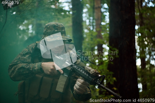 Image of soldier in action aiming  on weapon  laser sight optics