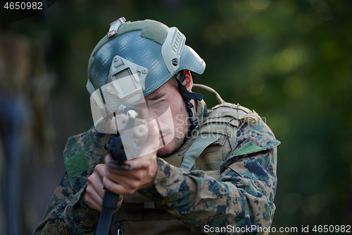 Image of soldier in action aiming  on weapon  laser sight optics