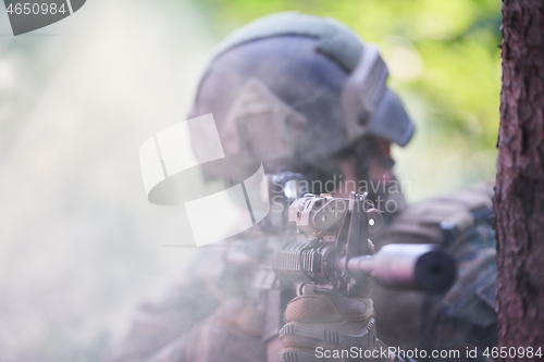 Image of soldier in action aiming  on weapon  laser sight optics