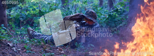 Image of soldier in action aiming  on weapon  laser sight optics