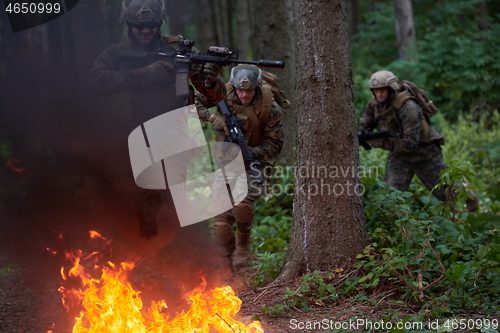 Image of Soldier in Action at Night jumping over fire