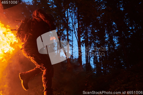 Image of Soldier in Action at Night jumping over fire