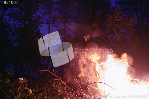 Image of Soldier in Action at Night jumping over fire