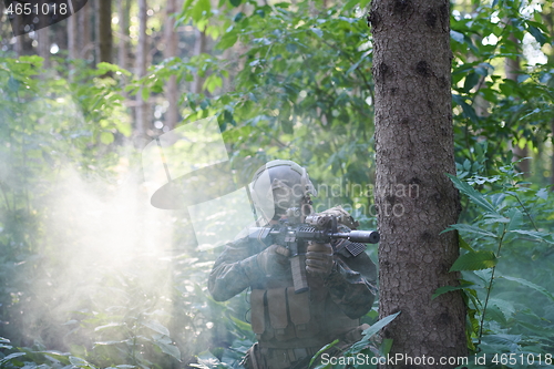 Image of soldier in action aiming  on weapon  laser sight optics